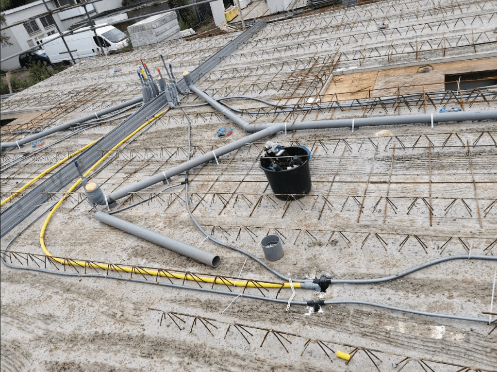 Grijs pvc leidingwerk aangelegd op de begane vloer van een nieuwbouw