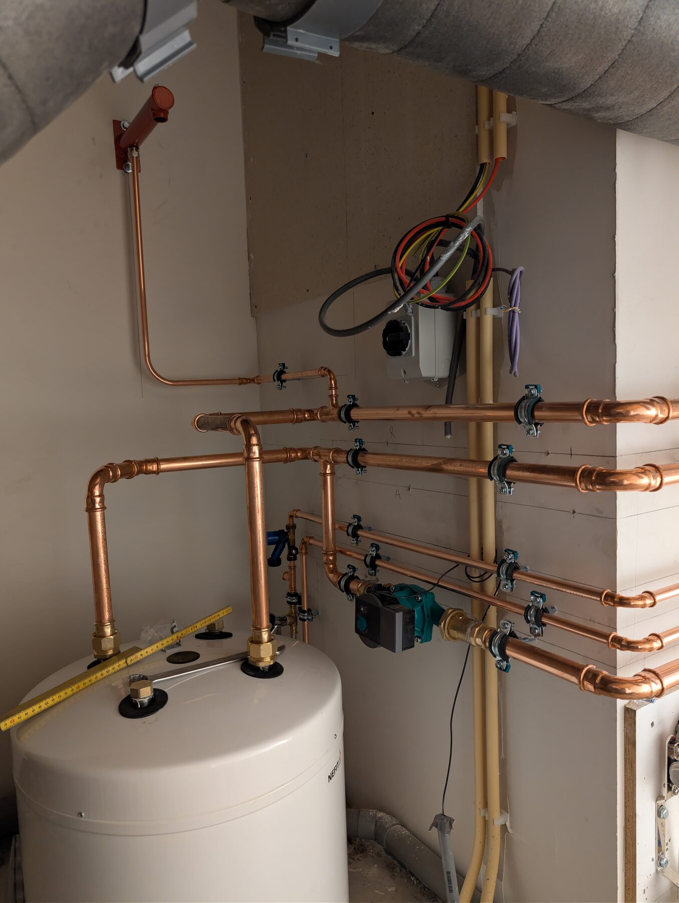 Koperen waterleiding met afsluiters, aangesloten op een boiler